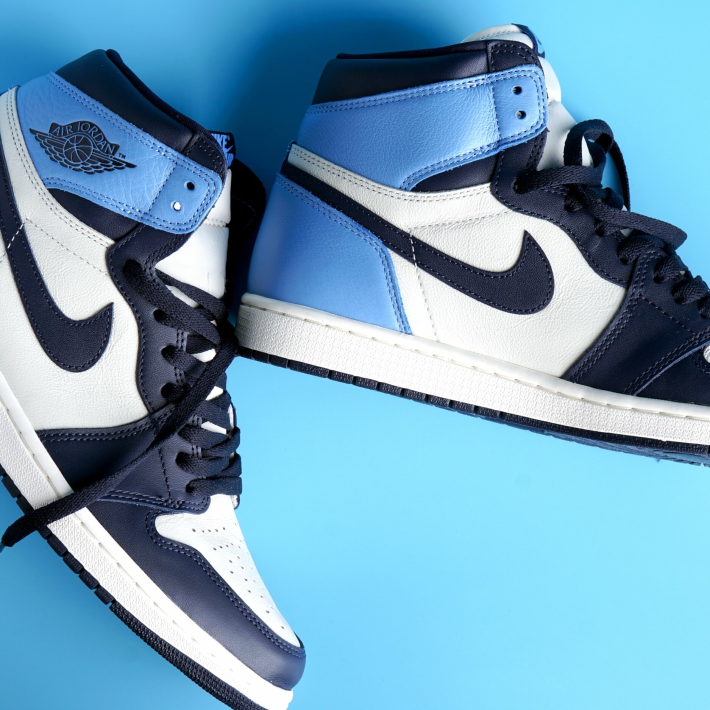 Nike Air Jordan 1 Obsidian Blue colorway sneakers on blue © Moma okgo/Shuttertsock