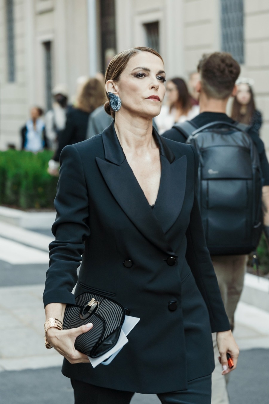 Look de soirée avec un costume noir et de grosses boucles d’oreilles