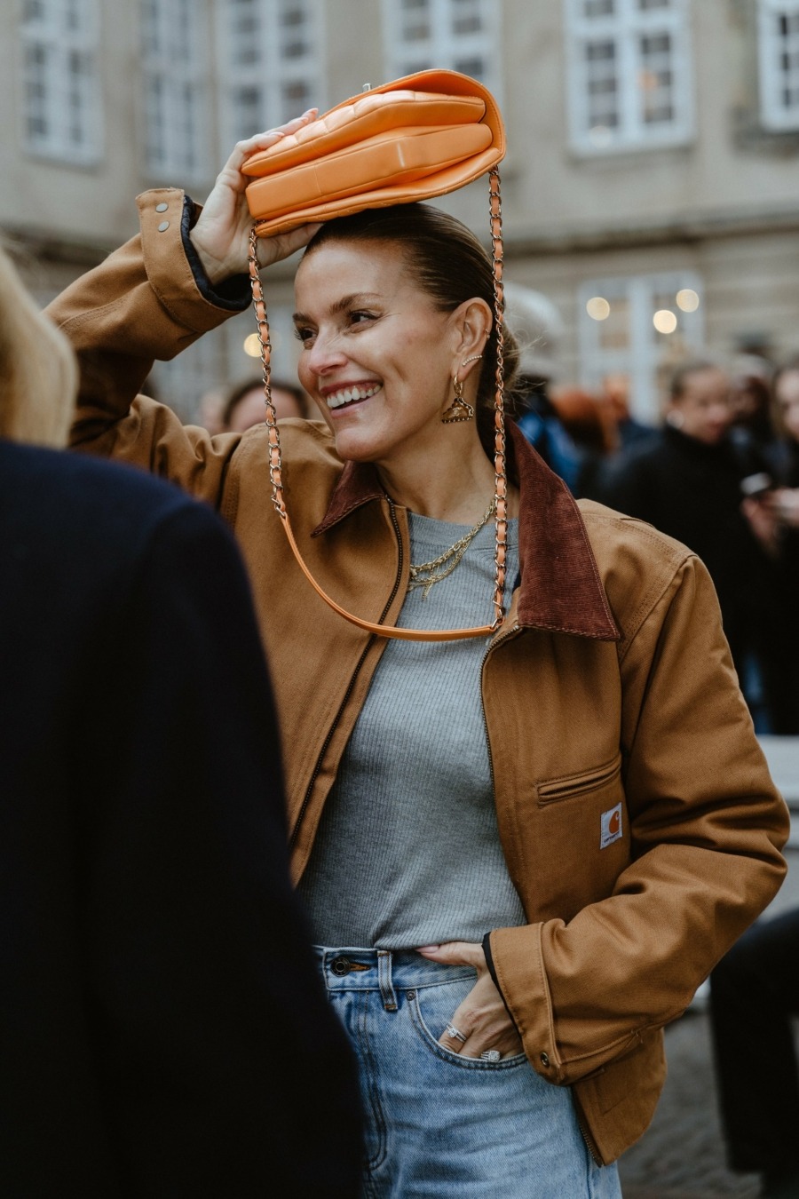 Un exemple de look avec une veste Carhartt, un jean et un sac orange