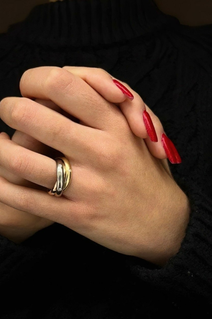 Main avec la bague Trinity de Cartier © 58 Facettes