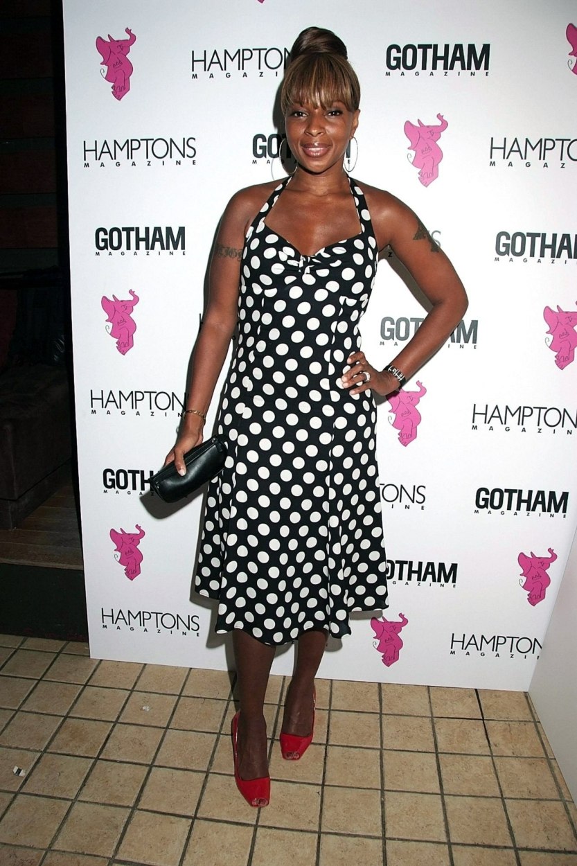 Mary J. Blige avec une robe à pois blancs sur fond noir décolletée