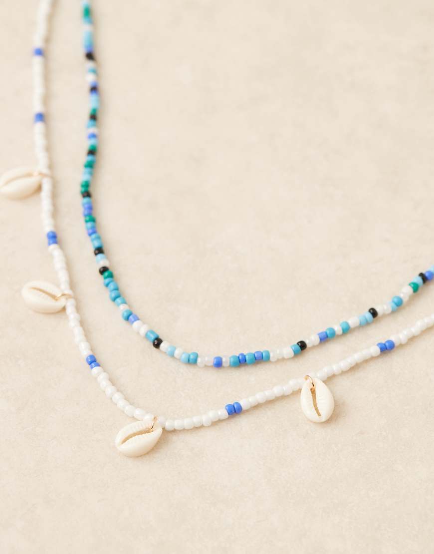 ASOS DESIGN – Chaîne de ventre multi-rangs avec perles avec coquillages fantaisie à <del>12,99 €</del> 10,00 € chez ASOS