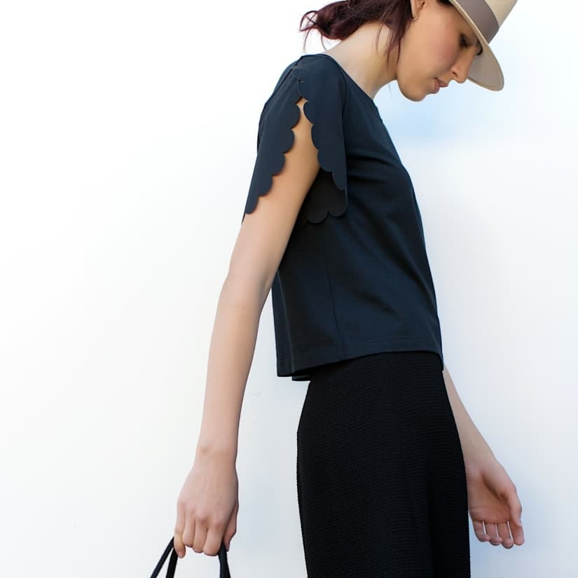 Mannequin de fille en vêtements à la mode sur un mur blanc. © Street style photo/Shutterstock