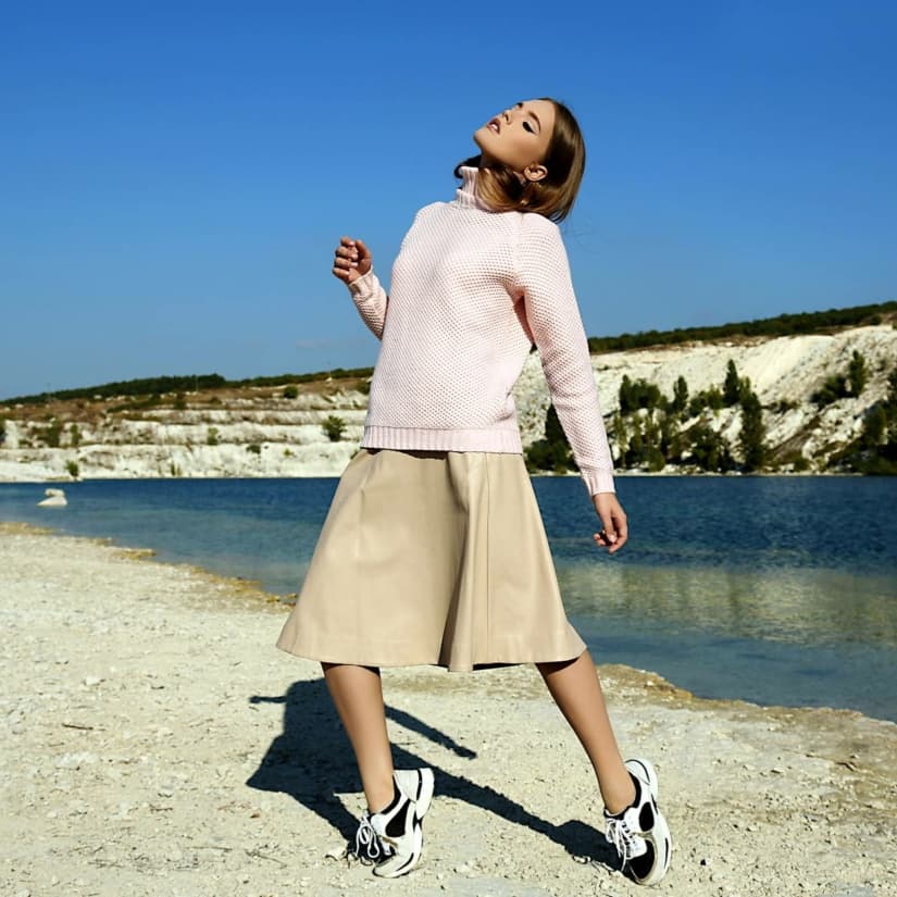 Belle femme en vêtements à la mode posant au bord du lac © Slava_14/Depositphotos