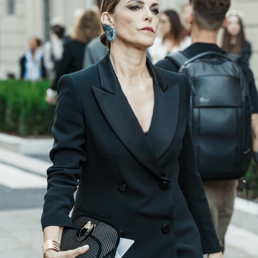 Look de soirée pour femme avec un costume noir et de grosses boucles d'oreilles